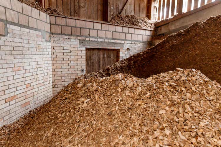Ein grosser Haufen Holzschnitzel in einem Lager.