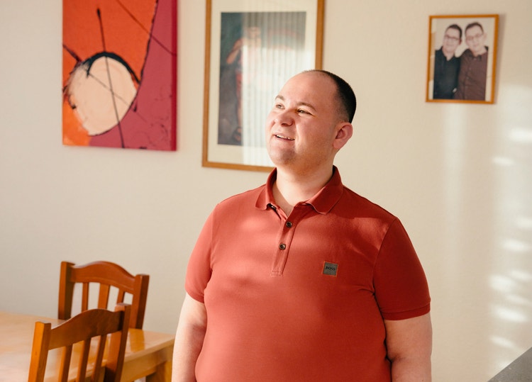 Dario Galanti steht zwischen Küche und Esstisch in seiner Wohnung .