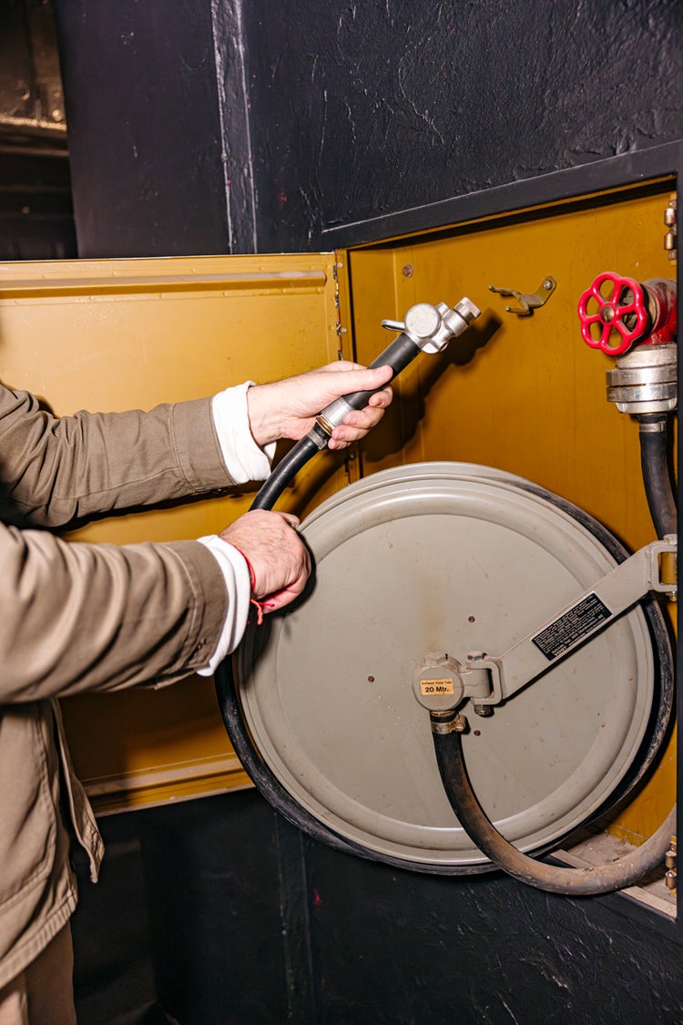 Marcel Hügel kontrolliert das Etikett mit den Wartungsdaten bei einem Feuerlöschschlauch.