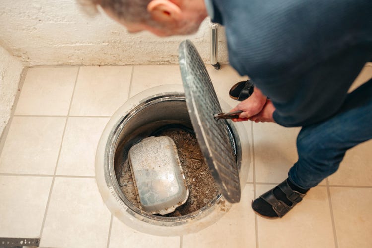 Dag Kappes blickt in den neuen Schacht mit der Rückstauklappe.