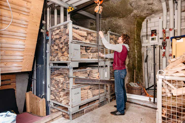 Innenansicht des Anbaus mit dem Chromstahl-Wassertank im Hintergrund, Holz für die Stückgutheizung und links einer kleinen Boulderwand