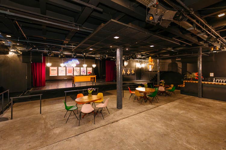 Neonlichter, dunkle Wände, Holztische und -stühle: im Innern des Clubs