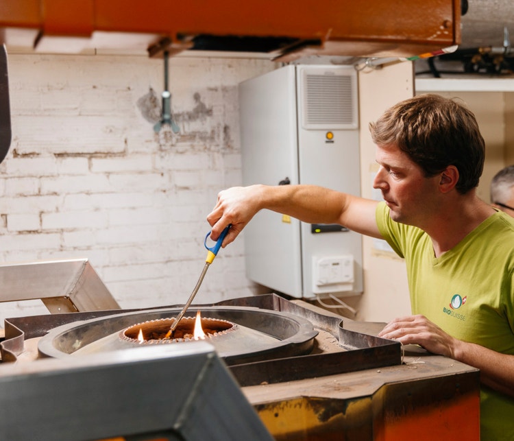 Michael Kipfer zündet die Holzschnitzel in der Pyrolyseanlage an.