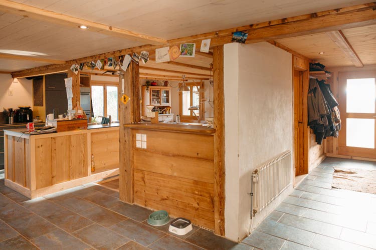 Rechts befindet sich der Eingang mit einer kleinen Garderobe, links die offene Küche und der Essbereich.