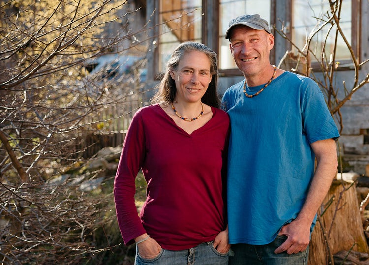 Sandra Haunreiter und Bänz Lüthi stehen vor ihrem Gewächshaus und blicken in die Kamera.
