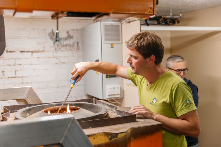Michael Kipfer zündet die Holzschnitzel in der Pyrolyseanlage an.