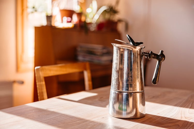 Une cafetière est posée sur la table. La poignée était jadis une poignée de porte.