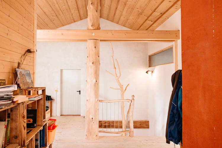 À l’étage. Au milieu se dresse un tronc qui sert de poteau faîtier.