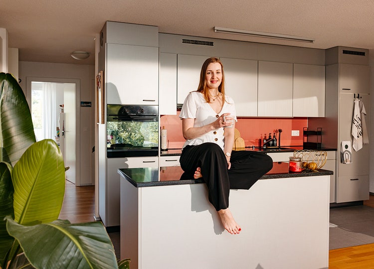 Alessia Russo assise chez elle, sur un élément de cuisine.