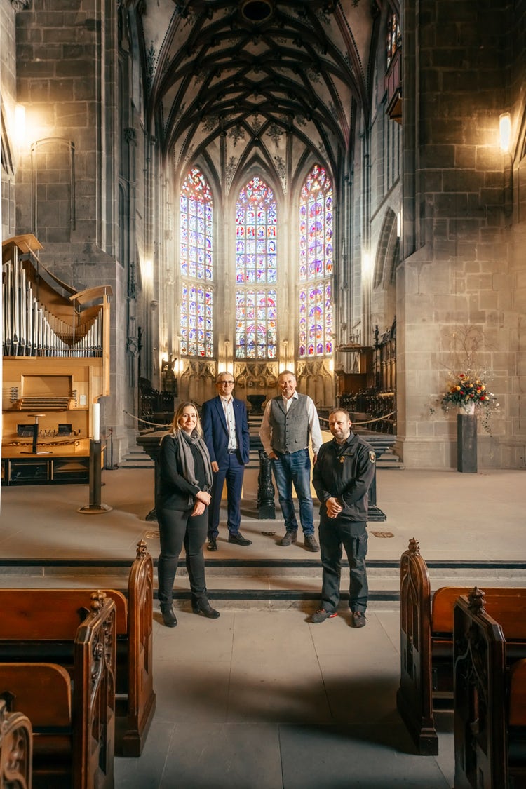 Annette Loeffel, architecte et ingénieure en cheffe pour la cathédrale, Stefan Dürig, président de la direction de l’AIB, Tino Perotti, expert en protection incendie auprès de l’AIB, et Lukas Ammann, responsable de la planification des interventions chez Protection et sauvetage Berne, posent dans la cathédrale de Berne.